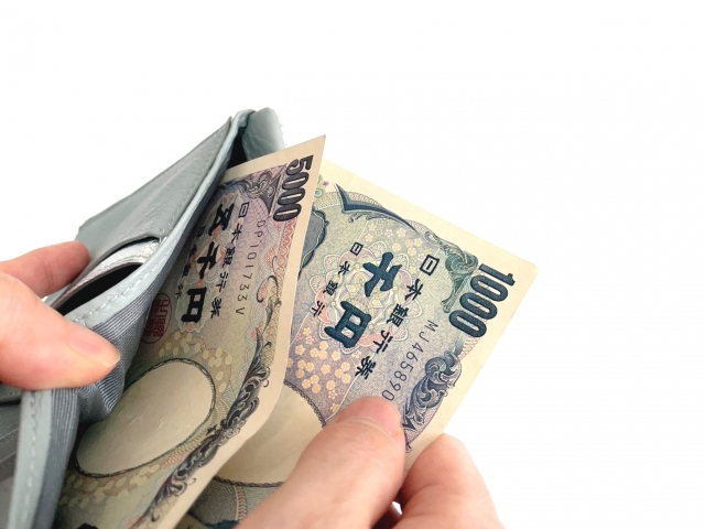 財布からお札を出している画像