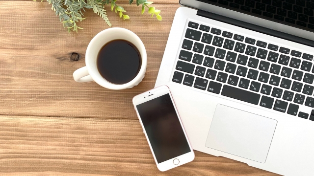 机の上に置かれているコーヒとスマホ画像